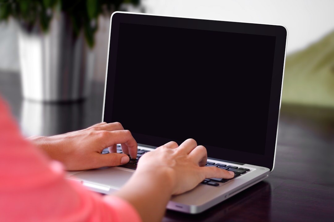Person typing a news article on a laptop
